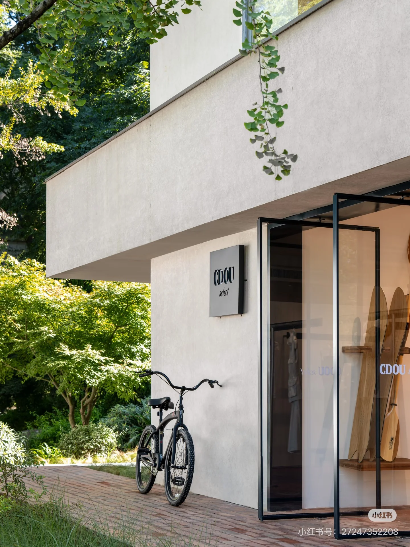 The CDOU select entrance, with a bicycle and surrounding greenery.