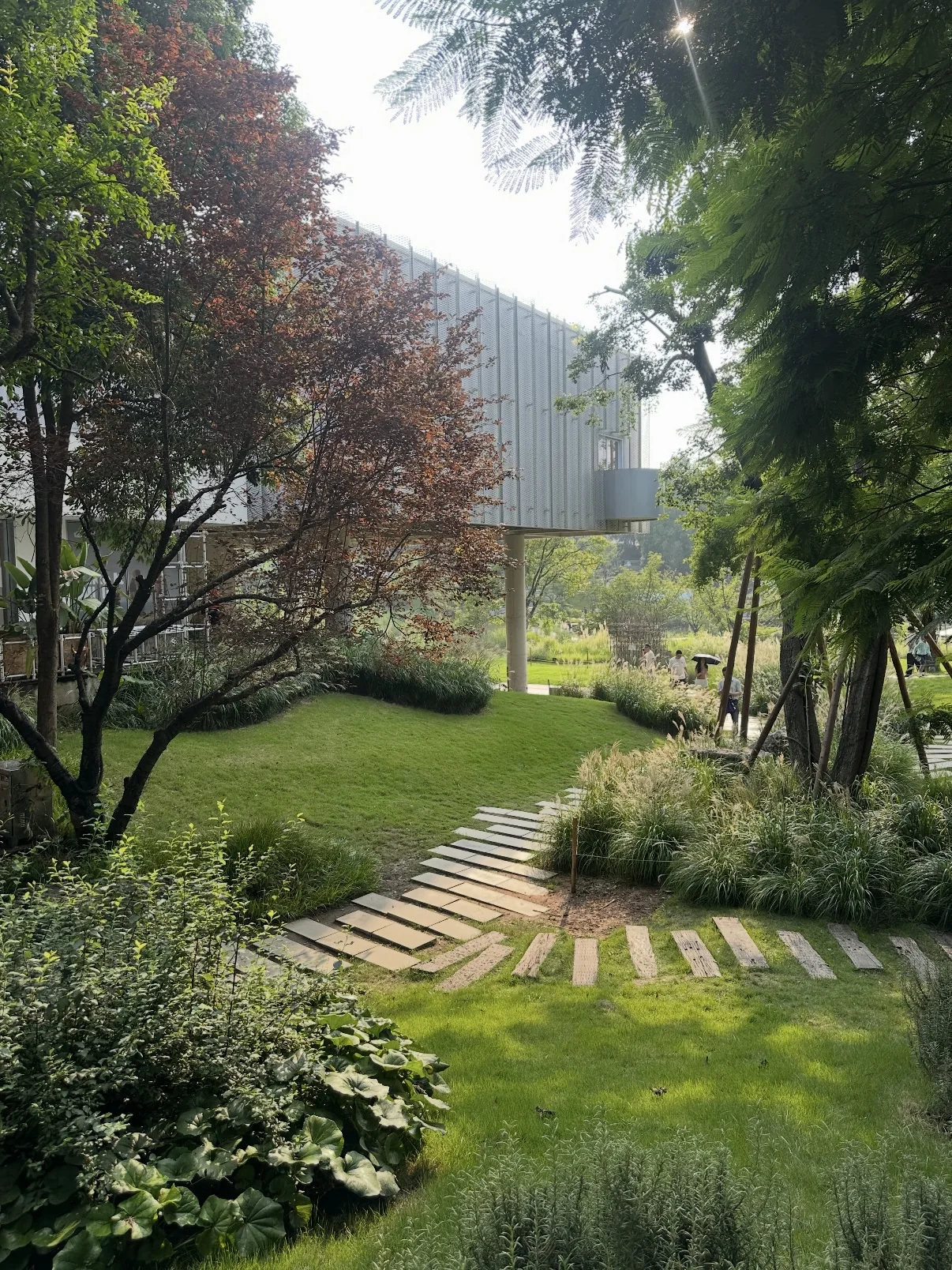 A stepping-stone garden path beside a light-colored building at Luxelakes CPI.
