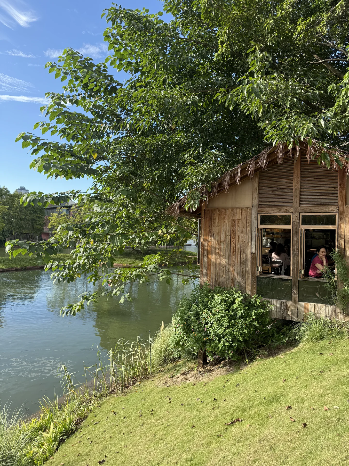 A wooden lakeside building framed by leafy trees at Luxelakes CPI.