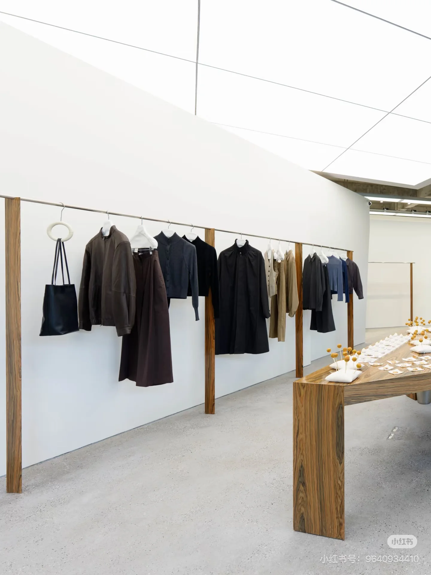 Clothing on wooden rails and a display table inside hug.