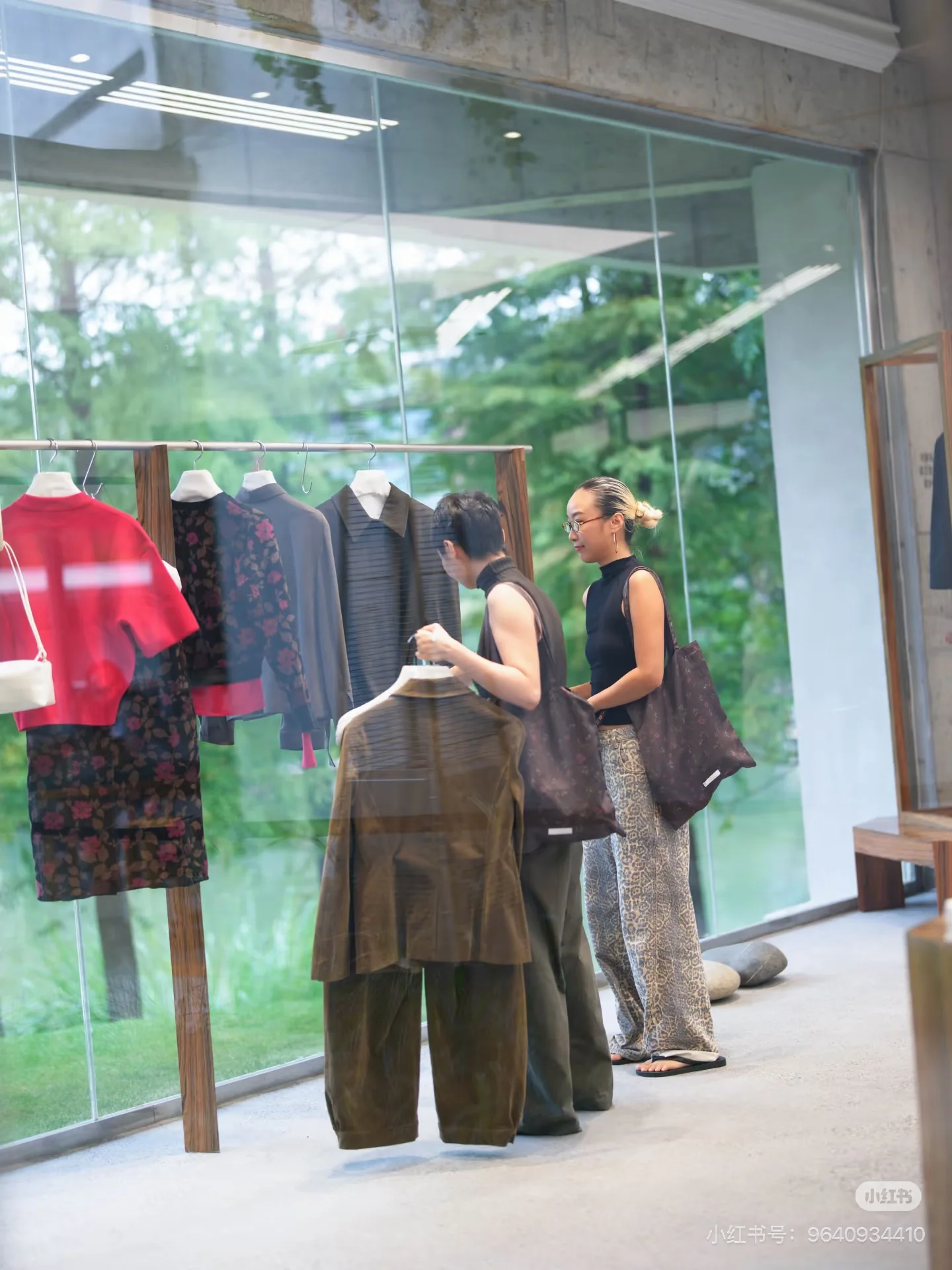 Visitors browsing clothing beside the large windows at hug.