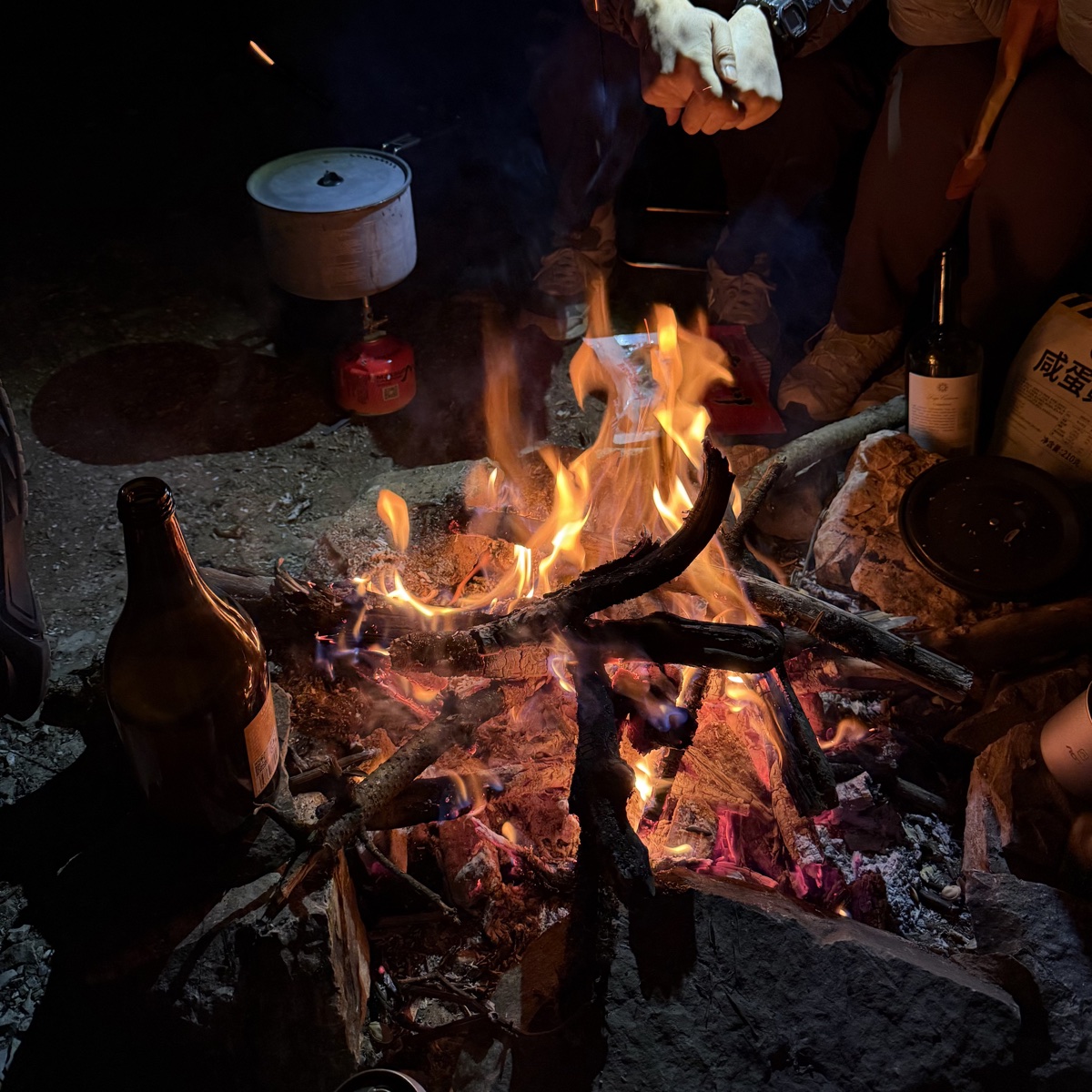 Friends gathered around a campfire at night
