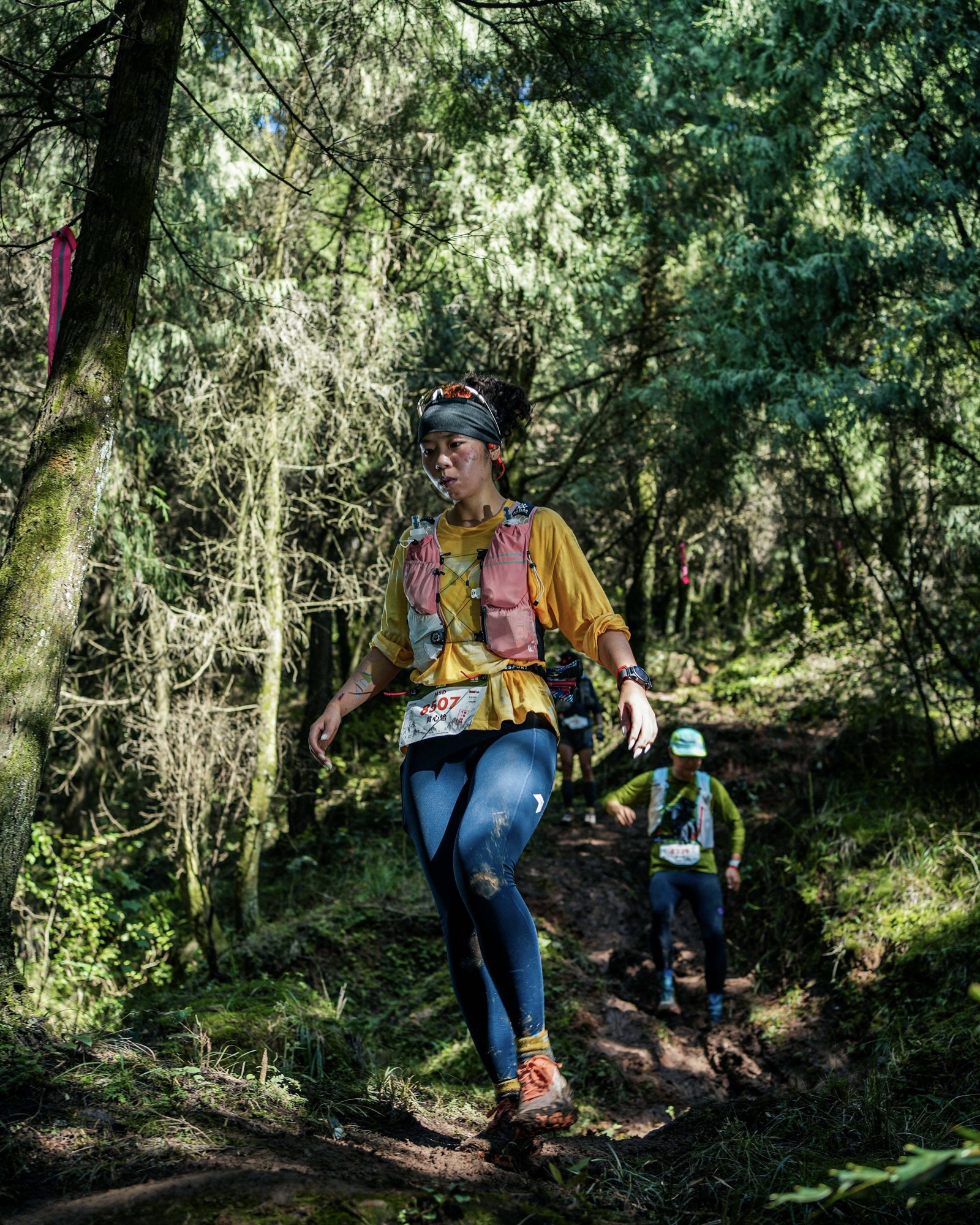 Kathy trail running through a sunlit forest