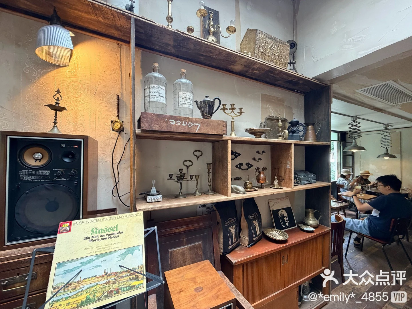 Wooden shelves, vintage objects and seating at LittleTravel CPI, with the original Dianping watermark.