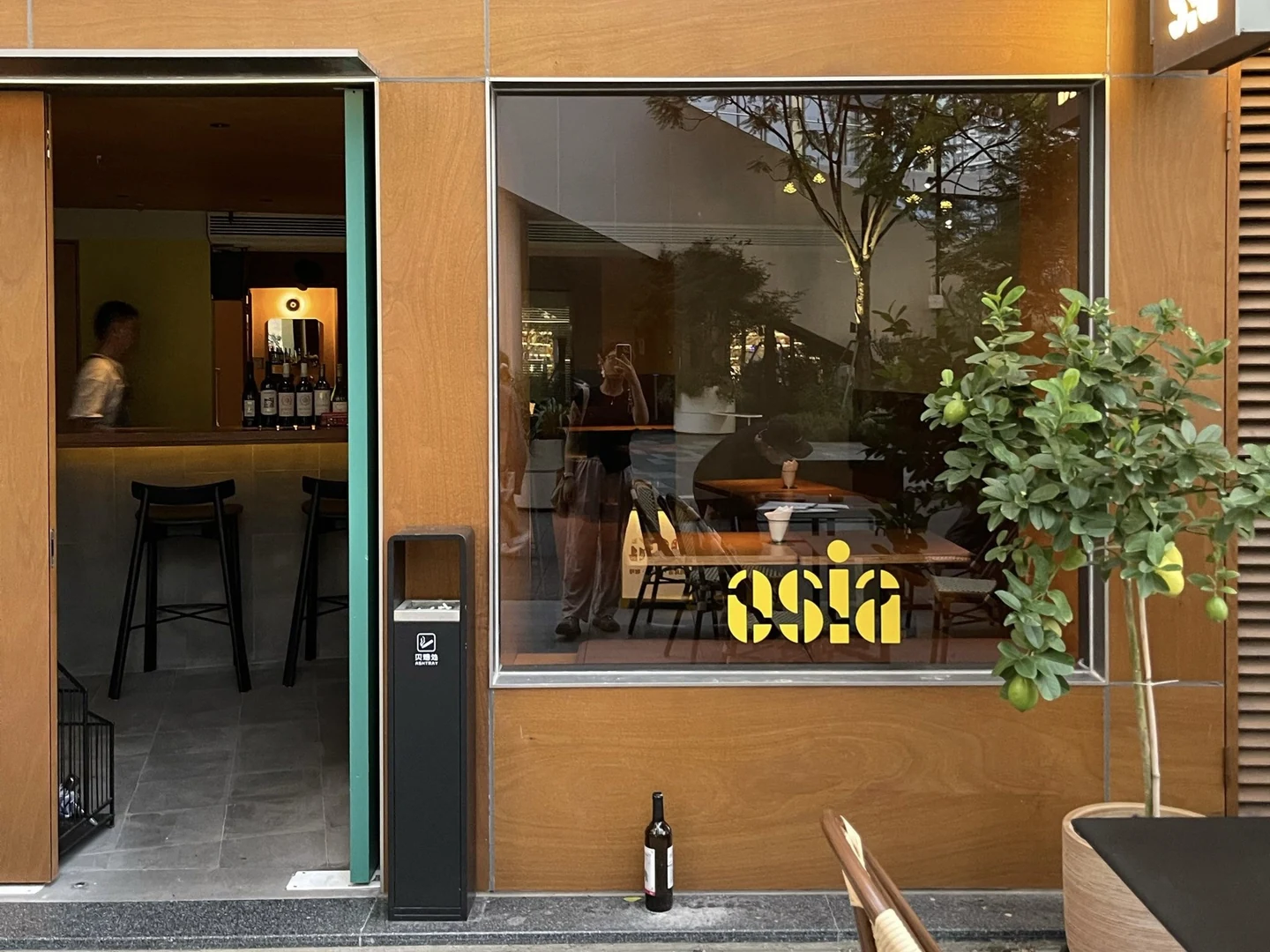 The wood-fronted entrance and yellow window lettering at O SIA.
