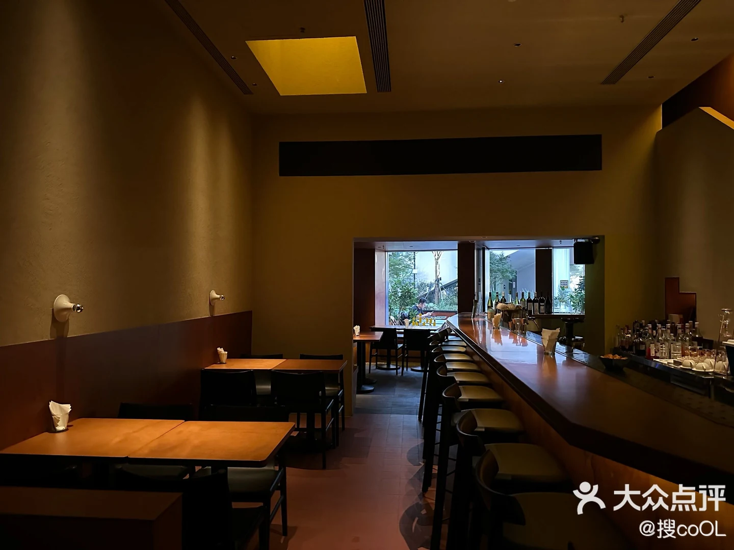 Warm-toned seating and a long bar counter inside O SIA, with the original Dianping watermark.