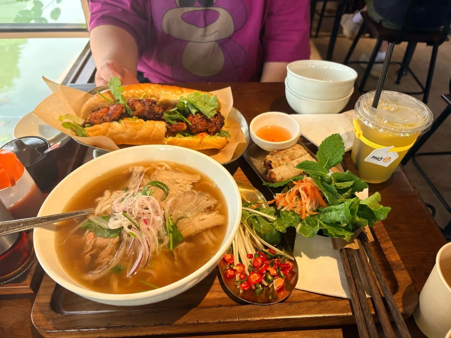 Beef pho, a banh mi sandwich, spring rolls and a drink at PHO U.