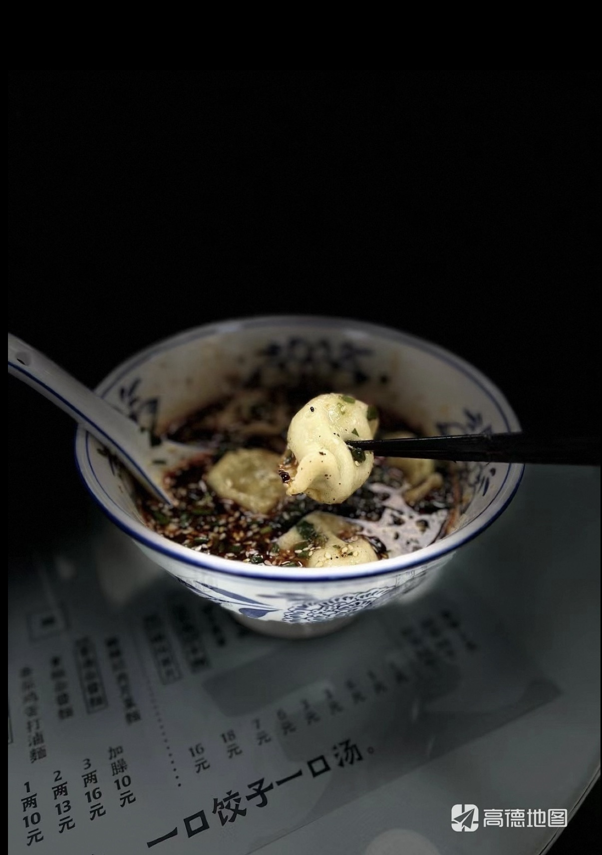 A dumpling lifted from a bowl of sour broth