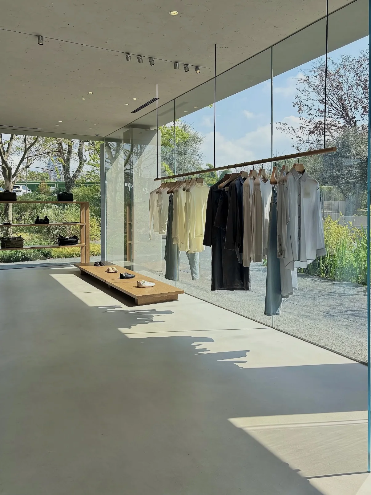 Sunlit clothing and shoe displays beside the windows of YEARLY PLAN HOUSE.