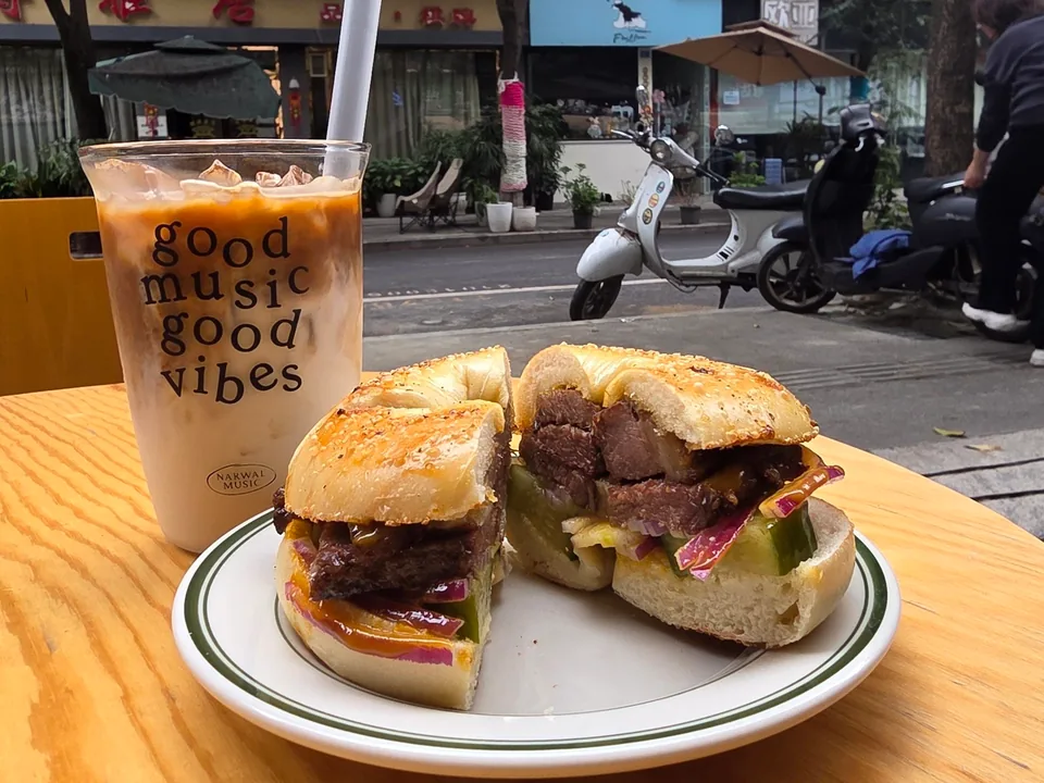 A bagel sandwich and iced coffee on an outdoor table at Bagel Camp