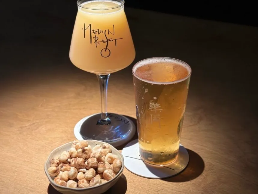 Two glasses of drinks with a small bowl of snacks at MEDISN