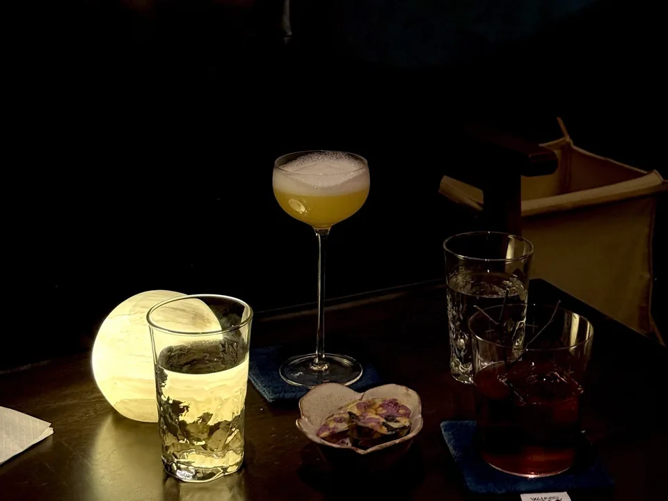 Drinks and snacks beside a softly glowing table lamp at WalkingNotes