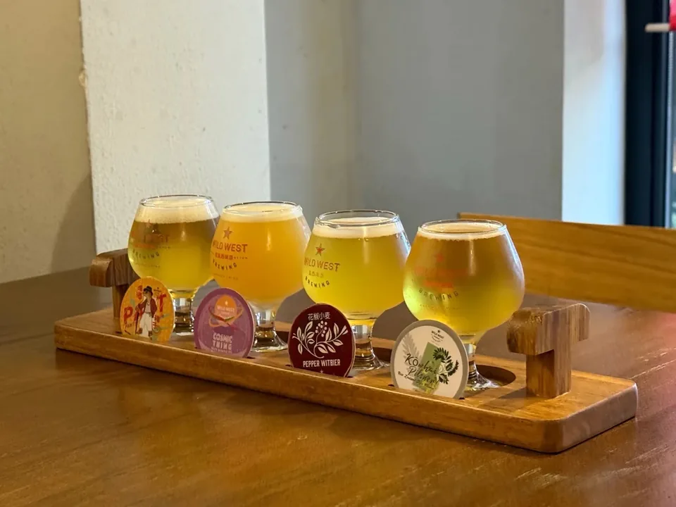 Four craft beers on a wooden tasting tray at Wild West Brewing