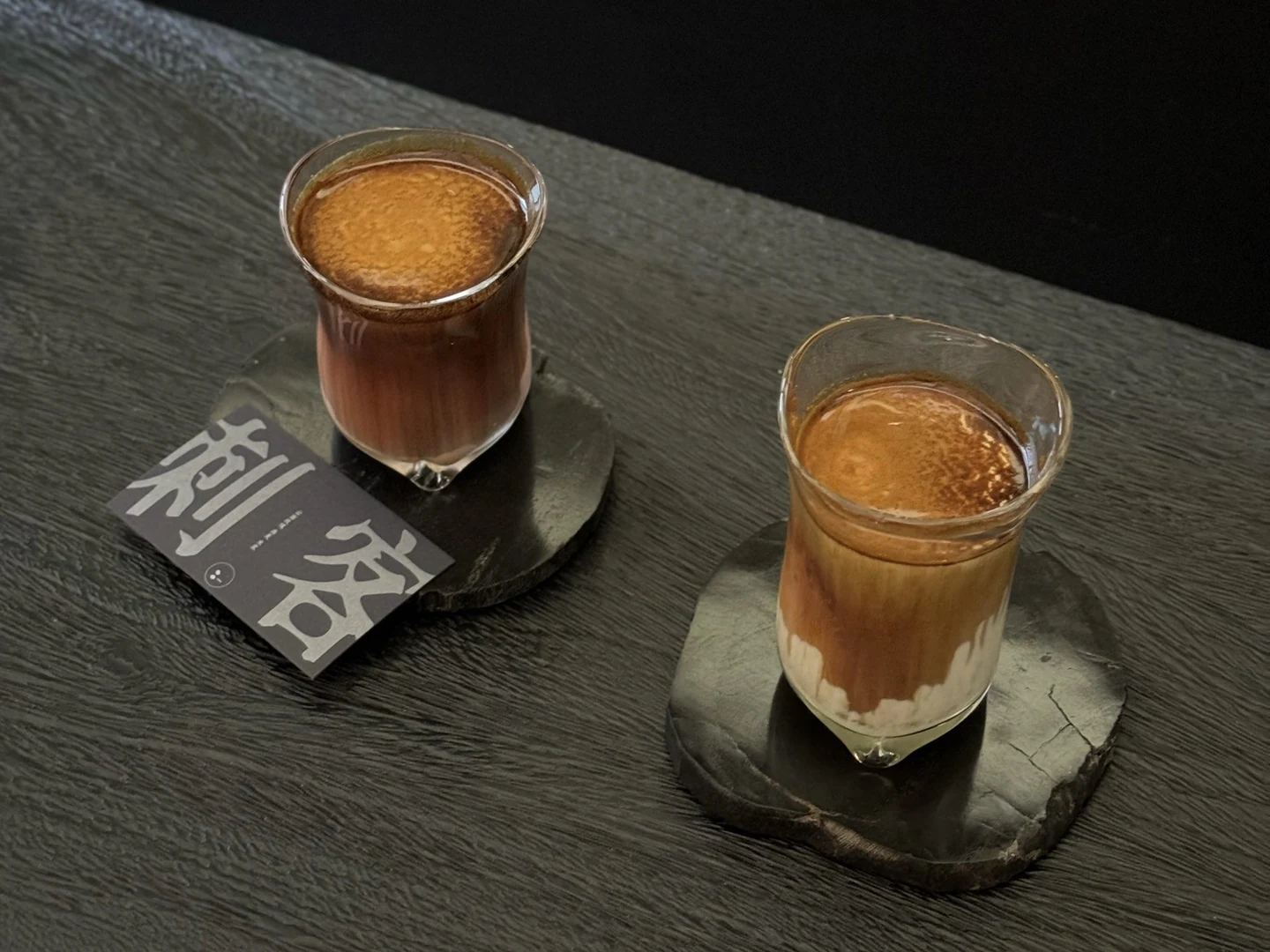 Two layered coffees on stone coasters at Yusuke.